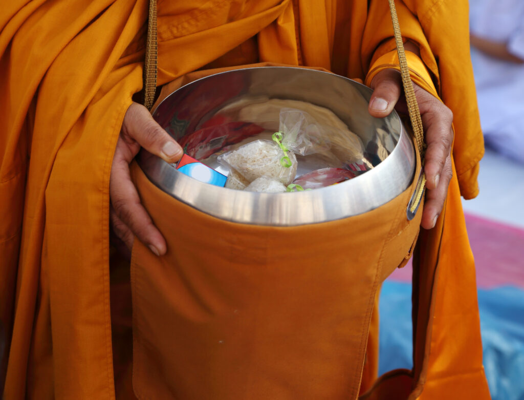 托鉢する東南アジアの僧侶。托鉢は僧侶の修行だけでなく、お布施をする人にとっても功徳を積むための大切な修行とされる　geargodz/ PIXTA（ピクスタ）